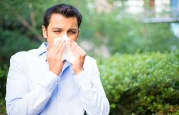 A man sneezing due to allergy.