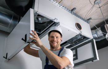 Smiling technician checking a HVAC system